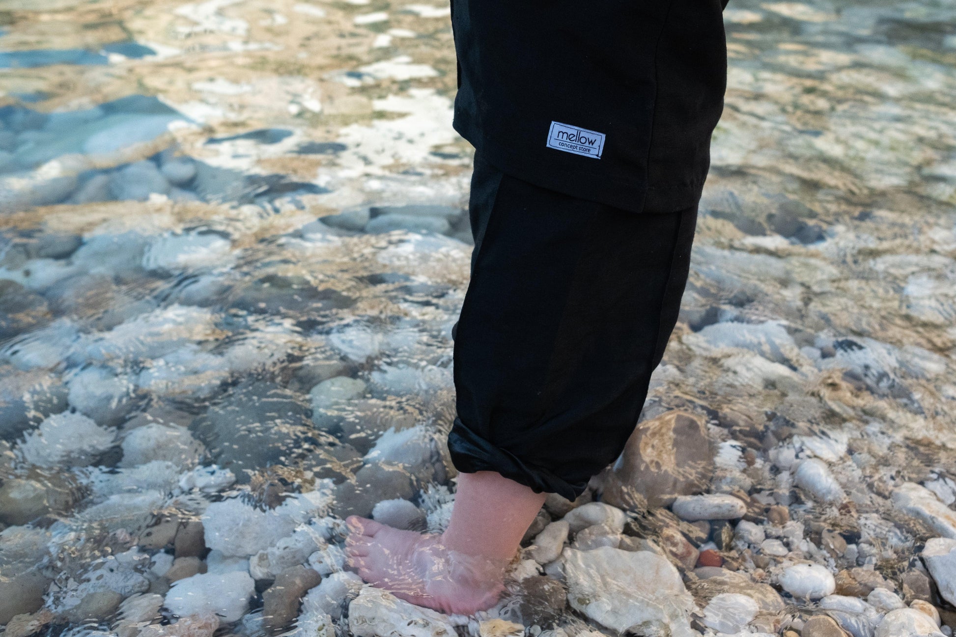 A person's feet standing on eco-friendly rocks in the water. with Ramie Baby/Kid Clothing Set - Charcoal by Mellow Concept Store