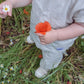A baby is standing in a sustainable field of flowers wearing the Ramie Baby/Kid Clothing Set in Beige from Mellow Concept Store.