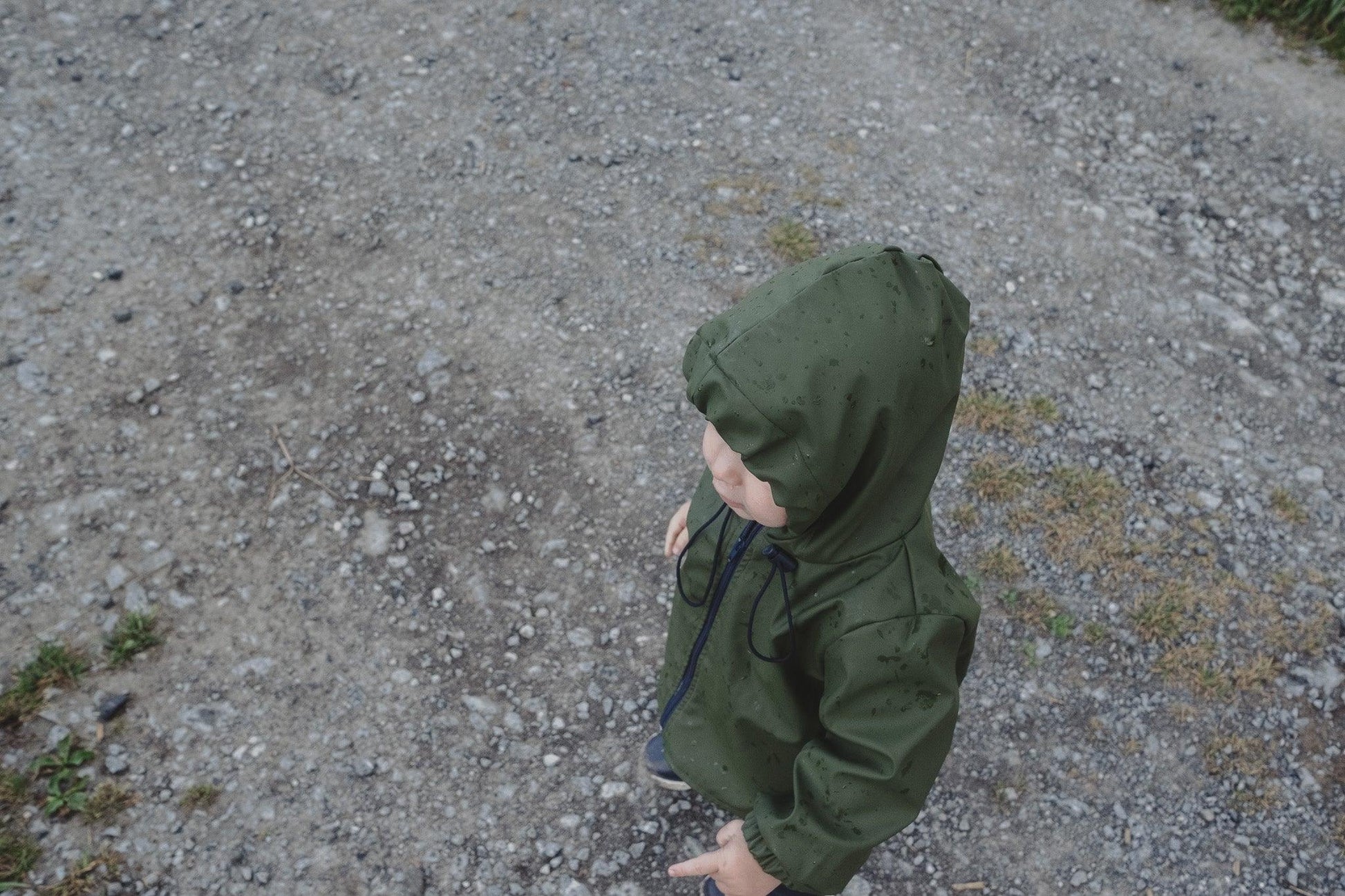 A young child in a Waterproof Baby/Kid Clothing Set - Khaki from MellowConceptStore stands on a gravel path, looking to the side.