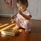 A baby is playing with an eco-friendly wooden xylophone.