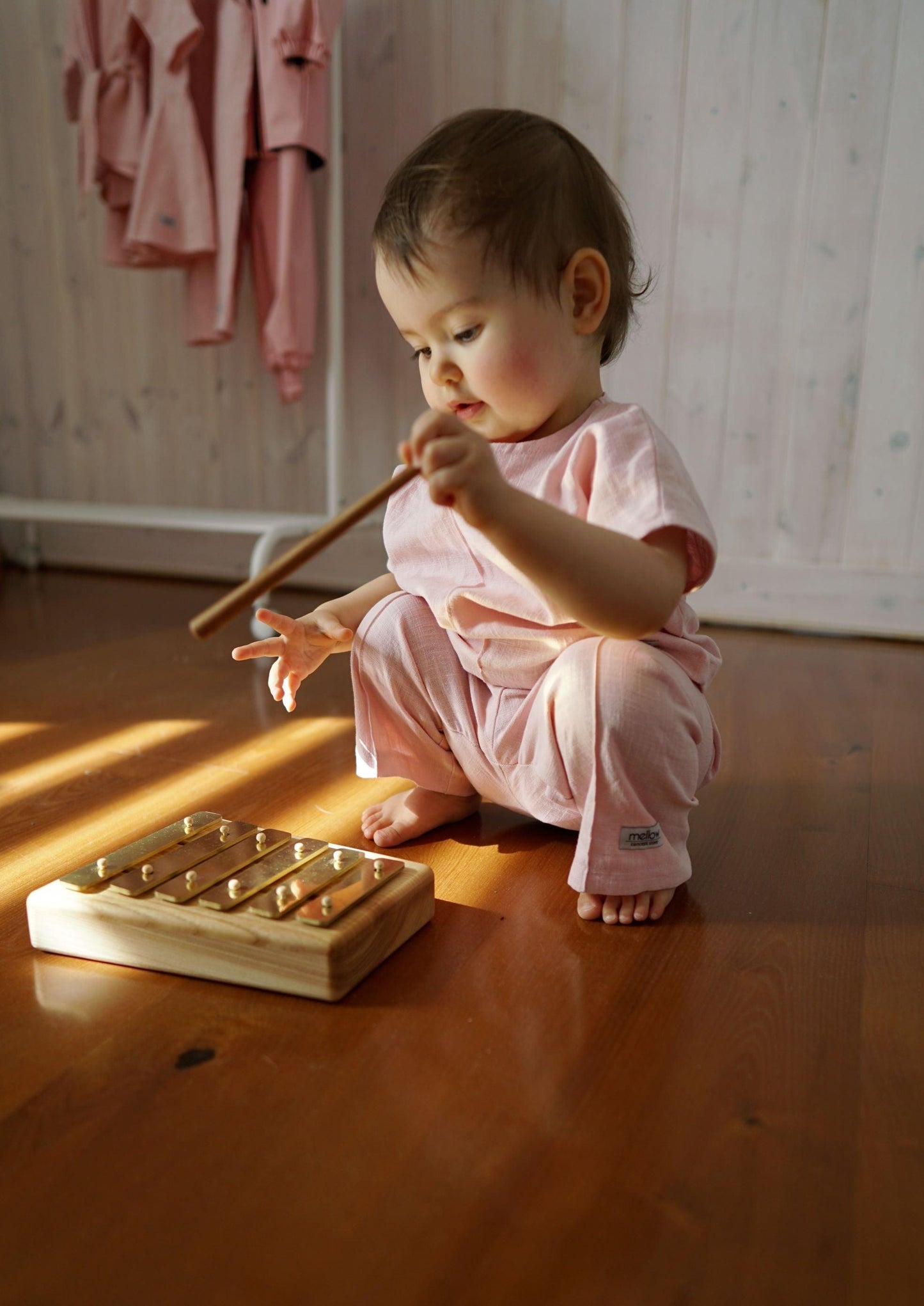 A baby is playing with an eco-friendly wooden xylophone.