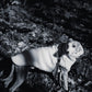 A black and white photo of a Woolen Dog Vest - White from Mellow Pet Store in the woods, surrounded by natural scenery.