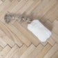A white Natural Sheepskin Dog Tug Toy from Mellow Pet Store is placed on a wooden floor, offering a touch of eco-luxury in pet care.