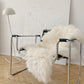 A white Natural Sheepskin Rug for Pet from Mellow Pet Store on a chair in an eco-luxury room.